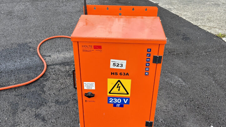 Oransje byggjestraumskap merka med høgspenning og 230 V, plassert utandørs.